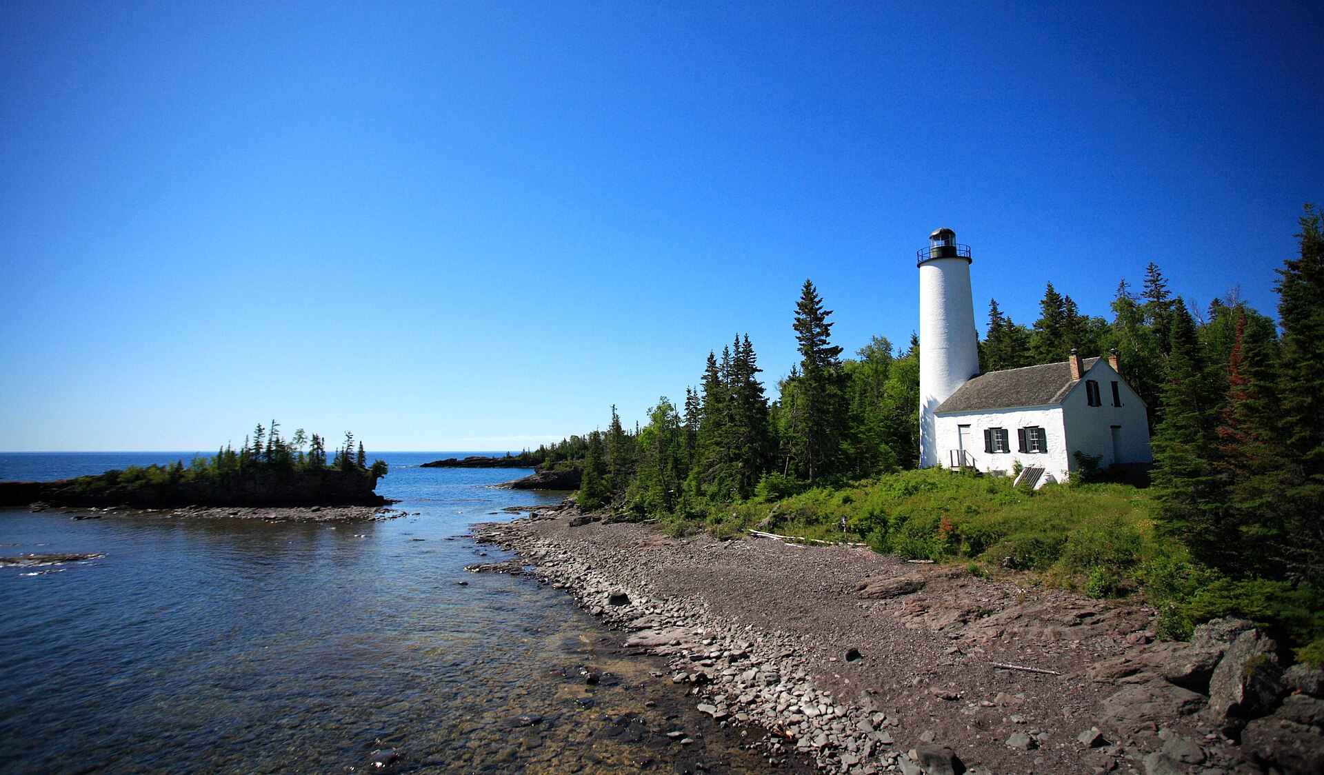 The white Rock Harbor Lighthouse on the rocky shore of Isle Royale, Michigan