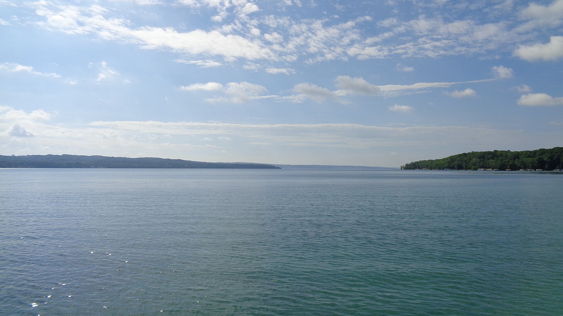 Clear blue-green water of Torch Lake in Antrim County, Michigan, under a summer sky