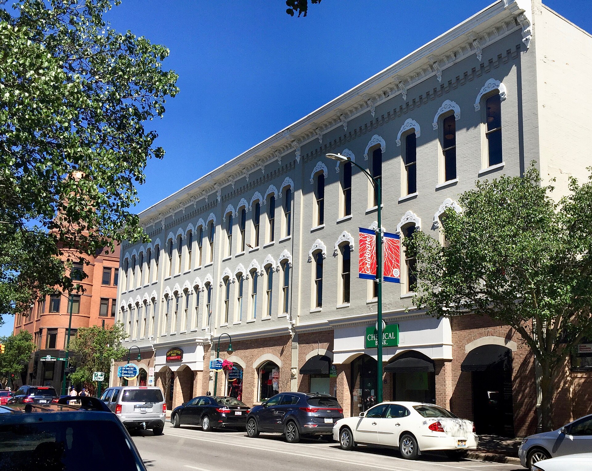 A restored three-story commercial block with ground-floor shops on Front Street in downtown Traverse City, Michigan, on a summer day